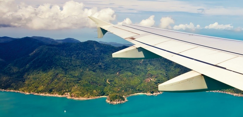 airplane-wing-tip-over-ocean-and-island-featured-shutterstock-137460476-830x400.jpg