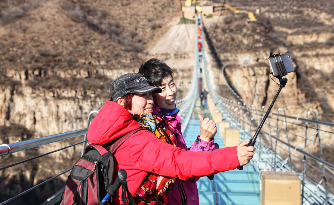 (171224) -- SHIJIAZHUANG, Dec. 24, 2017 (Xinhua) --  Tourists pose for photos on the glass suspension bridge at Hongyagu scenic spot in Pingshan County, north China's Hebei Province, Dec. 24, 2017. The 488-meter-long glass suspension bridge was formally open to the public Sunday. (Xinhua/Liu Peiran) (yxb) (Photo by Xinhua/Sipa USA)