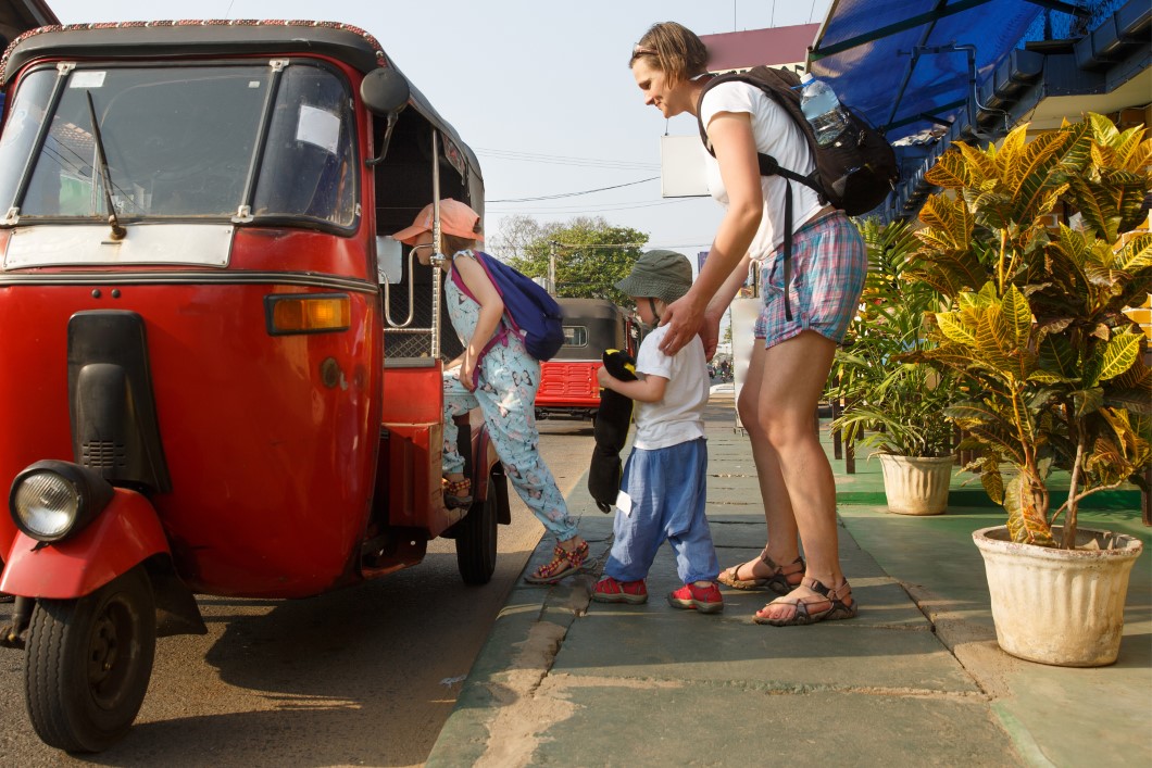 Family on vacation, mother and kids getting in a tuk-tuk, having fun.
