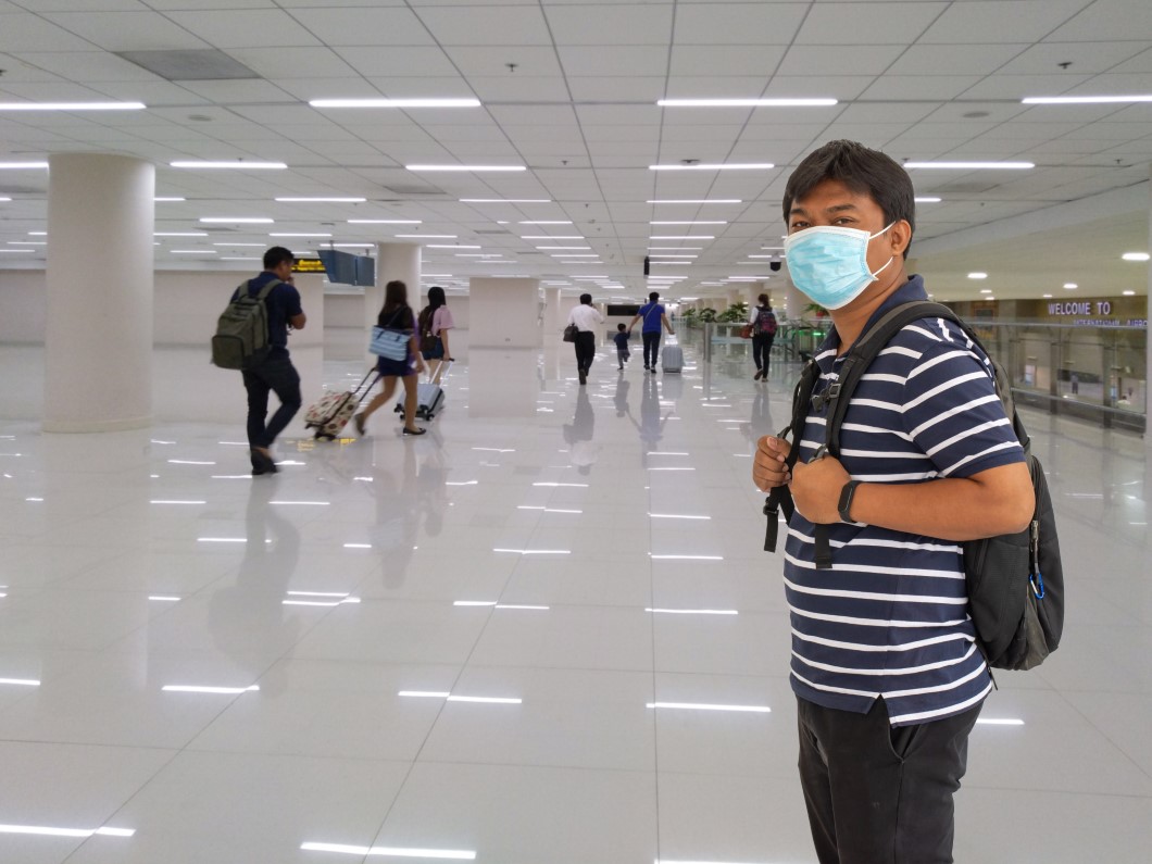 Young asian man in t shirt, protective disposable medical mask i